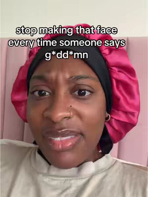 A close-up of a woman wearing a pink satin head covering and a white shirt. She is looking at the camera with a slightly furrowed brow. Text is overlaid at the top.