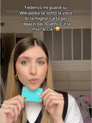 A young woman with blonde hair is centered in the frame, looking toward the camera with her mouth slightly puckered as if about to kiss. She holds up a light blue credit card with the Pixpay logo in her hands. Text overlay is present at the top of the screen written in Italian.