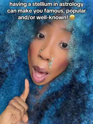 A selfie with a person with vibrant blue curly hair, fair skin, wearing a nose ring and holding up a finger. The background is a matching blue. Text overlayed at the top reads: "having a stellium in astrology can make you famous, popular and/or well-known!"