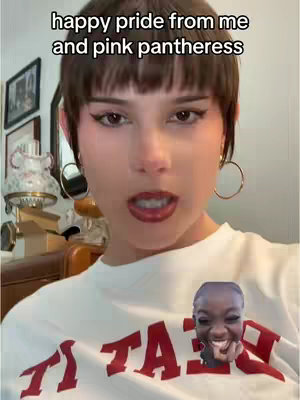 A selfie-style image with a woman at the center, sporting short brown hair and expressive makeup. The text overlay reads 'happy pride from me and pink pantheress'. A smaller image of another person is on the white T-shirt that the woman is wearing, and the shirt has the word 'TAKES' in red block letters.