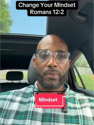 A man with glasses is seated in a car, facing the camera. Bold white text dominates the top of the frame, while a vibrant red and white text box hovers over the man's abdomen.