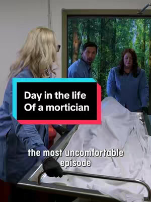 The cover image shows a behind-the-scenes view of a mortuary. In the foreground, a person wearing black gloves is next to a gurney covered with a white sheet. To the left, a blonde woman in a blue lab coat is seen from behind. In the midground, a man in a blue shirt is facing the camera with a shocked expression, and a woman is standing in the background. Text overlays include "Day in the life Of a mortician" in a large, centered pink and teal box, and "the most uncomfortable episode" in a smaller font below the title.