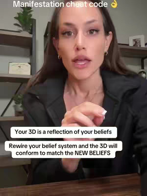 The cover image features a woman in a close-up shot, set indoors with a wooden table in the foreground and a bookshelf in the background. She's looking directly at the camera and has added text overlays in white boxes. The text gives manifestation advice.