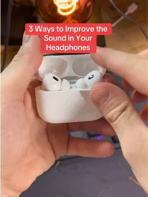 The cover image shows someone holding an open white headphone case, with the top half of the case visible, showcasing the earbuds. The background is blurred but appears to be an indoor setting. The text overlay is a red rectangular banner positioned at the top.