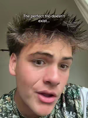 The cover image features a close-up of a young man with styled brown hair. The text overlay reads, \"The perfect trio doesn't exist...\". He's speaking, with a serious expression. He is wearing a patterned top with a silver chain. The background is a light, neutral color.