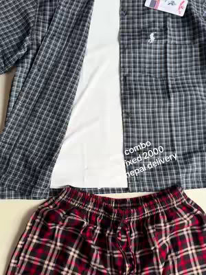 The image displays an assortment of clothing items, likely a combo set. There's a partially visible, open checkered shirt in black, white, and gray arranged over a white top. The bottom portion reveals a pair of red and black checkered shorts. The layout is clean, with the clothes neatly arranged, possibly for promotional purposes.