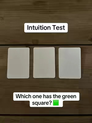 The image shows three white cards arranged in a row on a wooden surface. Above the cards, a white rectangular box reads "Intuition Test". Below the cards, another white rectangular box poses the question, "Which one has the green square?" followed by a green square icon.