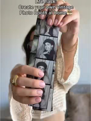 A woman holds up a strip of black and white photos taken in a vintage photo booth, the woman has long dark hair and is wearing a cream crochet top, rings, bracelets, and light pink nail polish. The photos are of a woman with a beret.