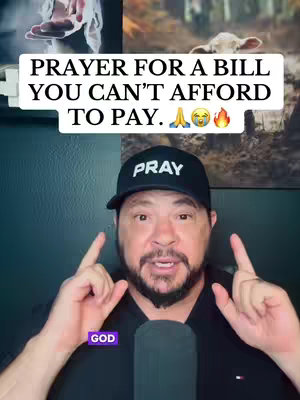 A man in a black cap and shirt is pointing upwards with both index fingers. Above him is a white rectangle with the text "PRAYER FOR A BILL YOU CAN'T AFFORD TO PAY." Above the rectangle is what looks like a painting of hands up in the air, with a golden hue. The image has a dark background. Also, there are images of landscapes in the background.