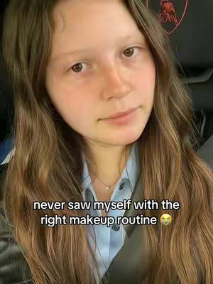 A young woman with long, wavy brown hair looks directly at the camera with a slight smile. She's wearing a collared shirt and a necklace. Text overlays the bottom of the image.