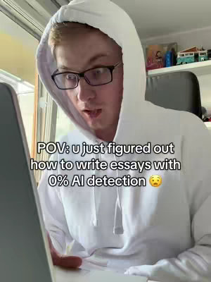 A young man wearing a white hoodie and glasses is looking at a laptop screen with a surprised expression. Text overlay on the image describes the scene.