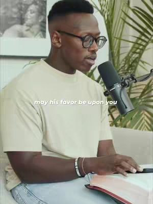 The cover image features a man with glasses and a microphone, seemingly recording a podcast or video. He is wearing a light-colored t-shirt and has bracelets on his wrist. In the background, there's a plant and a framed picture. The overall color scheme is neutral and soft.