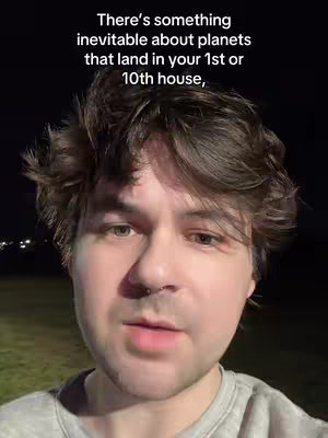 A selfie-style video featuring a person's face. The person has short, dark hair and is wearing a light-colored shirt. Against a dark background, a text overlay appears above the person's head.