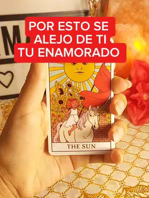 A hand holding a tarot card with a red overlay. The tarot card shows a person with a sun and a horse.