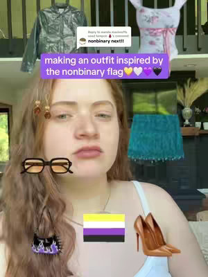 A selfie-style image features a person with long, wavy auburn hair looking at the camera with a neutral expression. They are wearing a white top, and the background includes a decorative top and a jacket and clothing items, suggesting a fashion-related theme. On the person's face sit a pair of orange-tinted glasses. Floating behind them is the non-binary flag, a small purse, and a pair of brown stiletto heels. There is a text overlay at the top that reads "making an outfit inspired by the nonbinary flag," and there is a comment on the background with the text "nonbinary next!!".