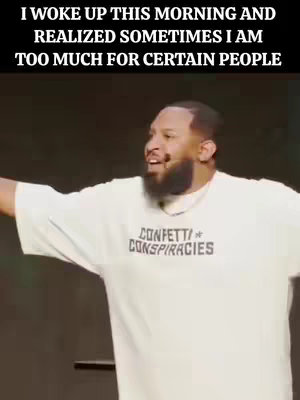 A man with a beard and short hair is shown looking slightly to the side with a happy expression. The man is wearing a light-colored shirt that has the words " CONFETTI CONSPIRACIES" printed on the front. The text "I WOKE UP THIS MORNING AND REALIZED SOMETIMES I AM TOO MUCH FOR CERTAIN PEOPLE" is superimposed at the top of the image on a black banner.