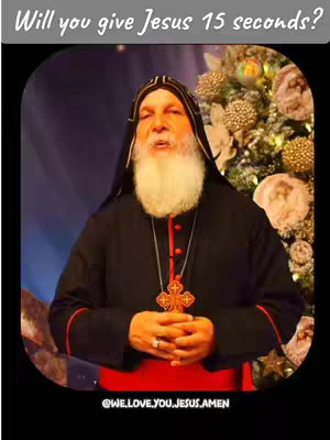 The image features a man in religious attire, positioned against a blurred background with Christmas-themed decorations. He's wearing a black robe with red trim, a tall black hat, and a gold cross necklace. The text overlay asks, 'Will you give Jesus 15 seconds?' The overall tone appears to be religious and inviting.