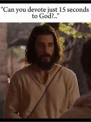 A man with long hair and a beard, dressed in a cream-colored tunic, looks slightly downward with a concerned expression. The background suggests an old stone building, with additional figures in the periphery. Text overlay at the top reads, "Can you devote just 15 seconds to God?..."