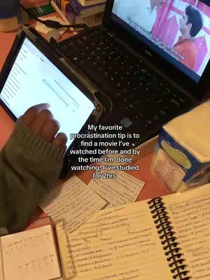 The cover image shows a desk setup with a laptop displaying a movie, a tablet showing a study app, an open notebook, and scattered papers, all suggesting a study session with a movie playing in the background. A hand is interacting with the tablet. The color palette consists mostly of desaturated colors.
