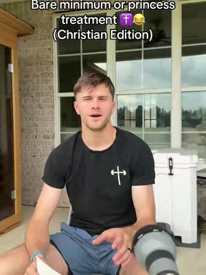 A man in a black t-shirt with a cross on it is sitting outside. The image is framed from the chest up. Behind him is a large clear window and the door to a building. The image has text overlayed on top.