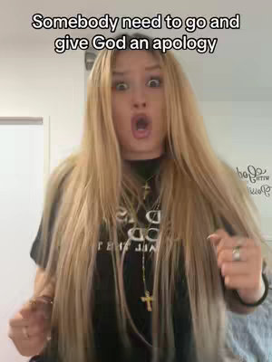 A young woman with long blonde hair is the focus, her face expressing surprise with wide eyes and an open mouth. She wears a black shirt and a cross necklace, against a blurred background. Text overlays the top of the image.