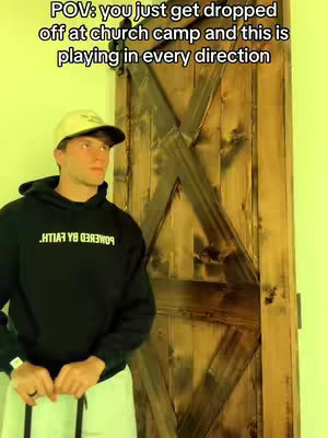 A young man wearing a baseball cap and a hoodie stands in front of a wooden door with a unique pattern with a caption on the top.
