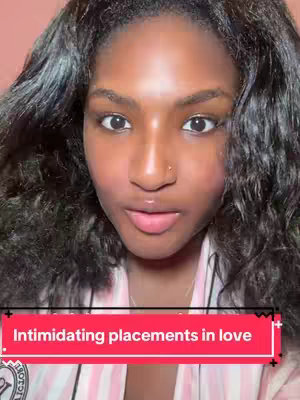 A close-up shot of a woman with dark, wavy hair and light makeup. She has a nose piercing and is wearing a light-colored top. A red rectangle with white text is overlaid on the image.