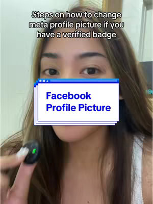 A woman is shown from the chest up, with a sign overlay obscuring her nose and mouth. The background is a pale greenish wall. The foreground contains a black object held in her fingers.