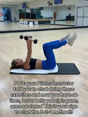 A person is lying on a mat with their legs raised, holding dumbbells. Text overlays the image, offering workout tips and motivation.