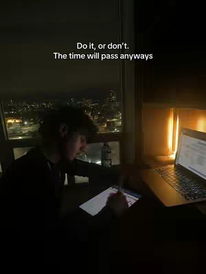 The cover image shows a person at a desk near a window with a city view at night. The person is wearing dark clothing. A laptop is visible on the desk, and the setting appears to be an apartment or office.
