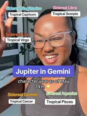 A woman with clear-framed glasses smiles at the camera in a selfie-style video. Text overlays with astrology-related information surround her face. She is in front of a green leafy backdrop