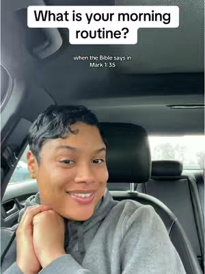 A woman in a gray hoodie smiles at the camera from inside a car. The top of the car and the car seat are behind her. Above her head is a white box containing the text question.