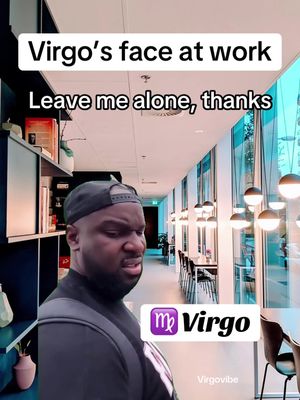 The image features a man with a serious expression, set against the backdrop of a modern office space. Above, text reads, 'Virgo's face at work,' followed by, 'Leave me alone, thanks.' A Virgo symbol sits in the lower right.
