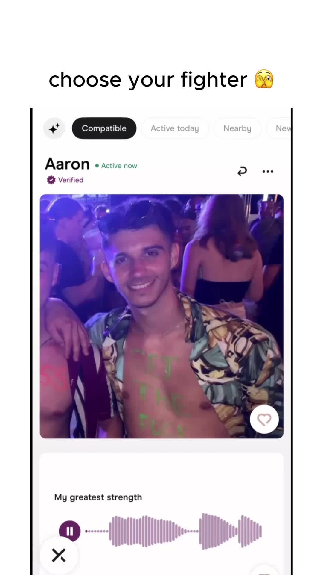 The cover image is a screenshot from a dating app, displaying a profile with the name "Aaron". The profile picture shows a man smiling, shirtless with writing painted on his chest. The background is blurred, suggesting a social setting with other people visible. Overlay text at the top reads "choose your fighter", and the app interface elements include profile details and other potential matches visible behind him.