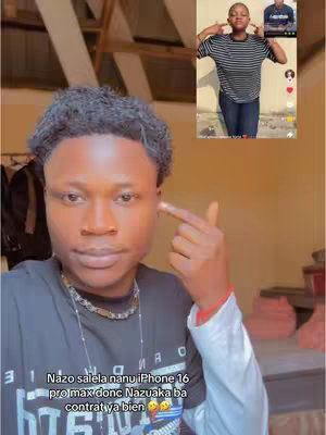 A selfie-style video cover featuring a young man in a black shirt, pointing a finger towards his face. In the top right corner, there's a smaller embedded video of another person. The background appears to be an indoor setting with a tan or light brown color scheme, and a glimpse of what looks like clothing on a rack to the left.