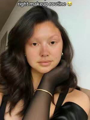 A selfie-style cover image featuring a young woman with long, dark brown hair. She has light skin and wears minimal makeup. The top half of her face is visible, with her hand in a sheer black opera-length glove resting on her cheek. She's wearing a gold bracelet and has small earrings. The background is a light neutral color. The text overlay in the top-left corner is in a white, casual, capitalized font.