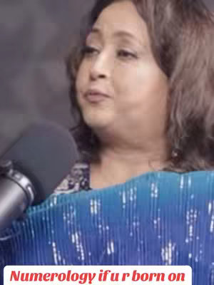 A woman with brown hair is speaking into a microphone, with text overlayed on the lower portion of the image.