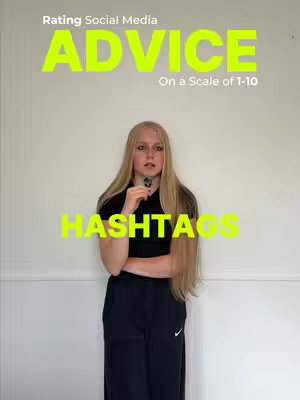 A young woman stands in front of a plain background, holding a small object like a microphone, with text overlaying the image in a bold, neon-yellow font. The text displays "Rating Social Media ADVICE On a Scale of 1-10" at the top, and "HASHTAGS" at the bottom. She is wearing a black top and athletic pants with a Nike logo, and her long blonde hair hangs down.