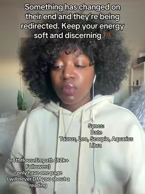 A medium shot featuring a person with dark, curly hair, wearing a white hooded sweatshirt, and has white earbuds. Text overlays are present at the top and bottom left, and on the bottom right. The background is softly blurred of a room.