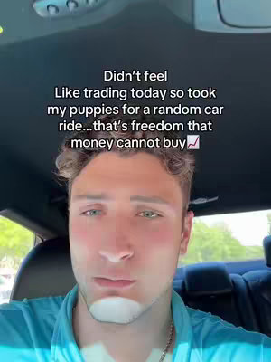 A man is sitting in a car, the camera facing his upper body and face. Above him, white text is overlayed on the image.
