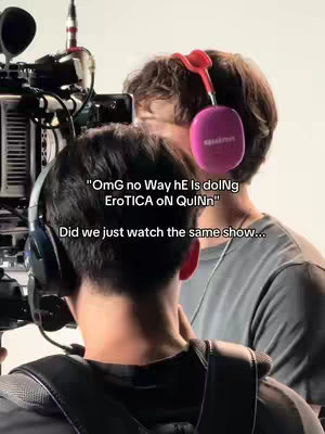 A behind-the-scenes shot of a film set. Two individuals are captured from the back, wearing headphones and focusing on a camera. Text overlays are added to the image.