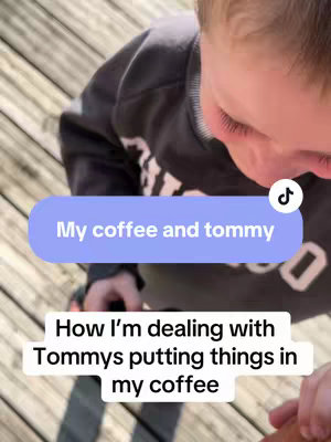A top-down view of a child's face, partially visible, looking down at something held in the hands. The background is a wooden deck with sunlight. Text overlays include a comment and a description of the situation.