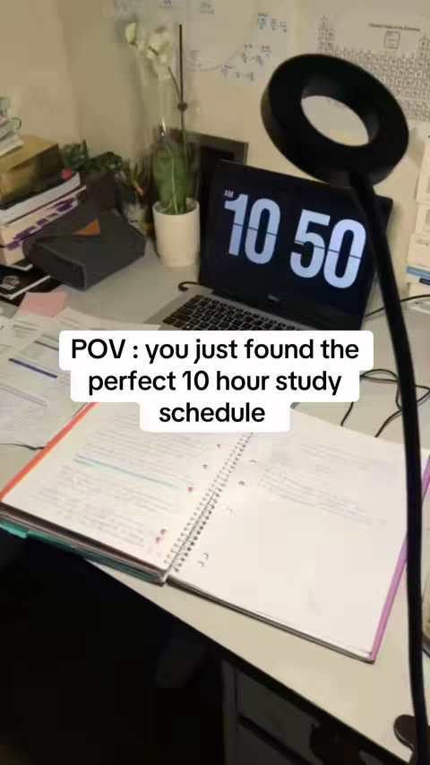 The image shows a desk setup for studying. A laptop displays the time as 10:50 AM. A notebook and papers are open, suggesting study materials. The lighting is provided by a modern ring light. Other items include a plant, books, and a small bag.