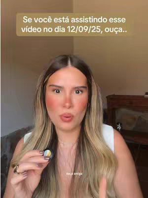 A woman with long, wavy blonde hair looks directly at the camera, holding a small object in her hand and pursing her lips. The background has a blurred, neutral color. A text overlay in a rounded rectangle is at the top.