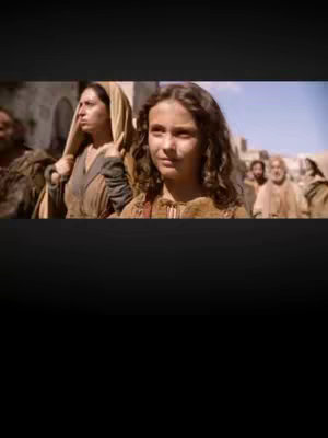The cover image shows a scene from a movie with a young girl as the focus, surrounded by other people in historical attire and setting. The girl is in the center, looking towards the viewer. The background suggests an outdoor environment, likely a city, with buildings and people in the distance. The image is framed with black borders above and below.