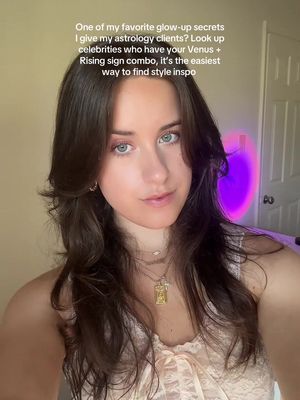 A selfie-style shot featuring a young woman with long brown hair and blue eyes. She is looking directly at the camera with a neutral expression. The background includes a wall, a door, and a purple halo light. There is text overlayed on the image.