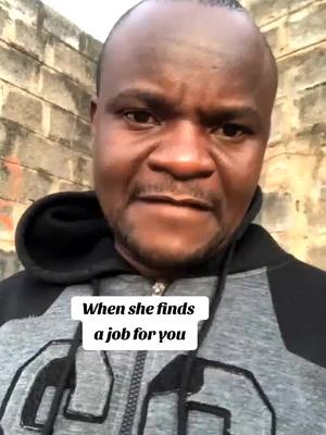 A man with a shaved head and a focused expression is framed from the chest up. He is wearing a gray and black hoodie. Text overlays on the cover image: 'When she finds a job for you'. The background is a rough brick wall.