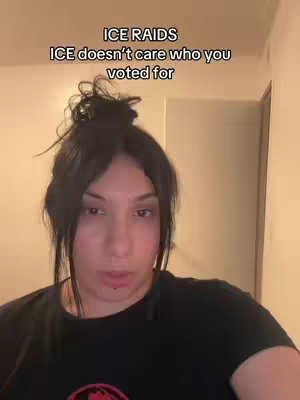 A woman with dark hair in a bun is centered in the frame, looking directly at the camera with a neutral expression. Text overlays, "ICE RAIDS" and "ICE doesn't care who you voted for," are positioned above her head.