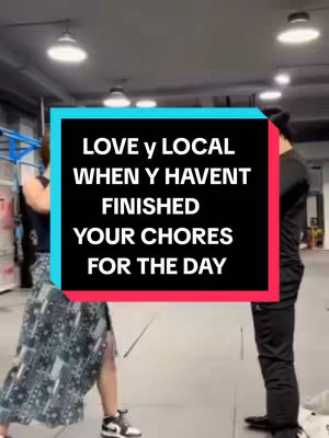 The image shows a woman in a patterned skirt and sneakers and a man with his back to the camera in a grey building. A centered text overlay reads LOVE y LOCAL WHEN Y HAVENT FINISHED YOUR CHORES FOR THE DAY.
