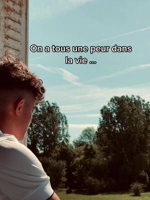 A person, seen from the back and slightly from the side, looks out of a window, with trees in the background and text on the top.